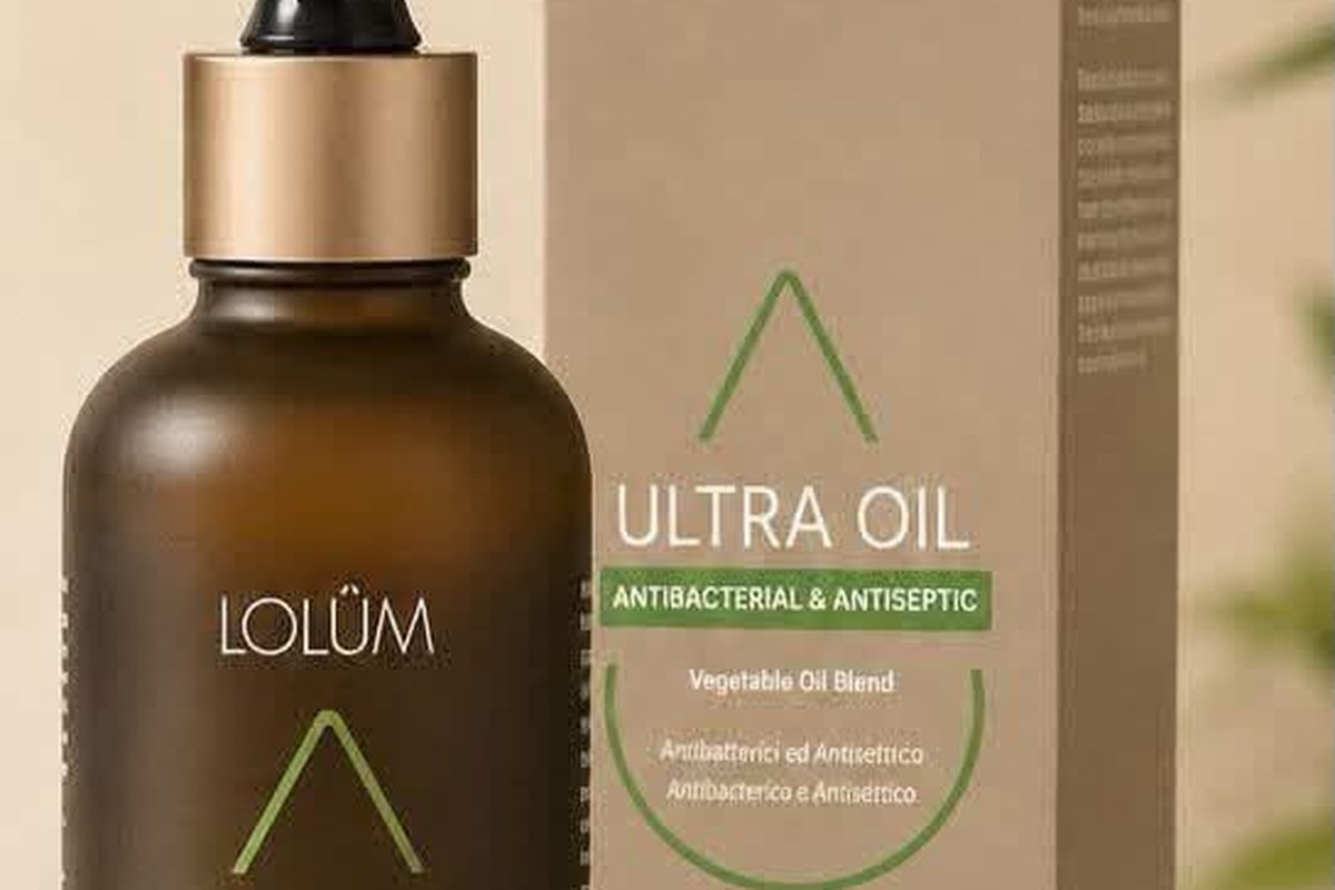 A dark amber dropper bottle of plant oil beside its beige box and an olive branch in warm daylight